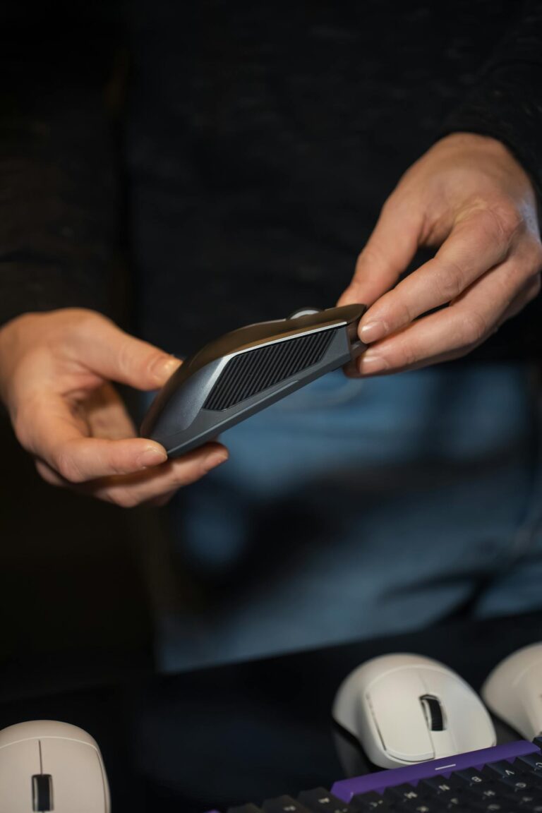 Close-up of a person examining an ergonomic wireless mouse, highlighting technology use.