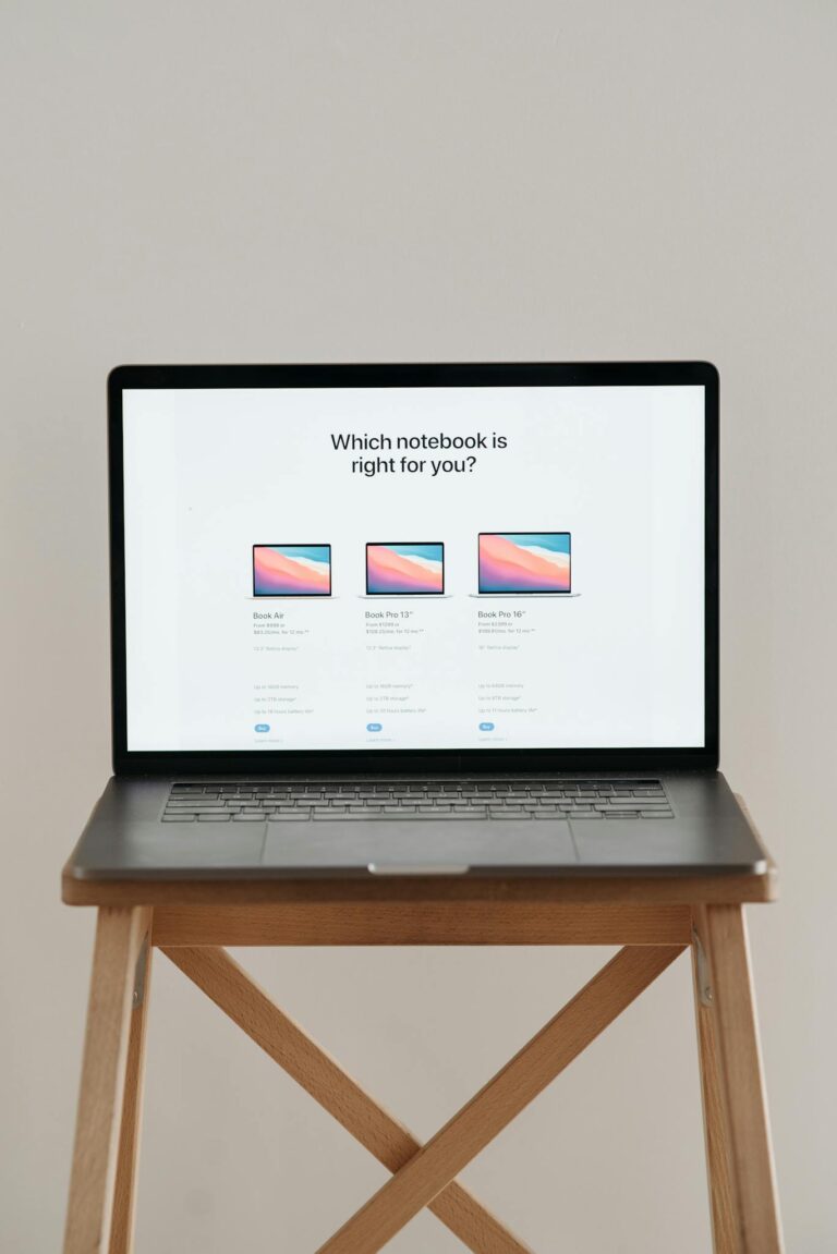 Laptop on a wooden stand with screen showing notebook comparison.